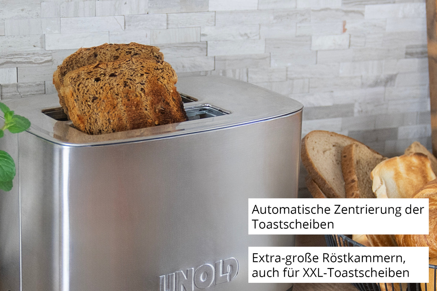 Der Unold Toaster Thommy, abgebildet mit zwei Scheiben Vollkornbrot und mehr auf einem Schneidebrett, verfügt über extra große Schlitze für XXL-Toast und eine automatische Zentrierung, wie im deutschen Text beschrieben.