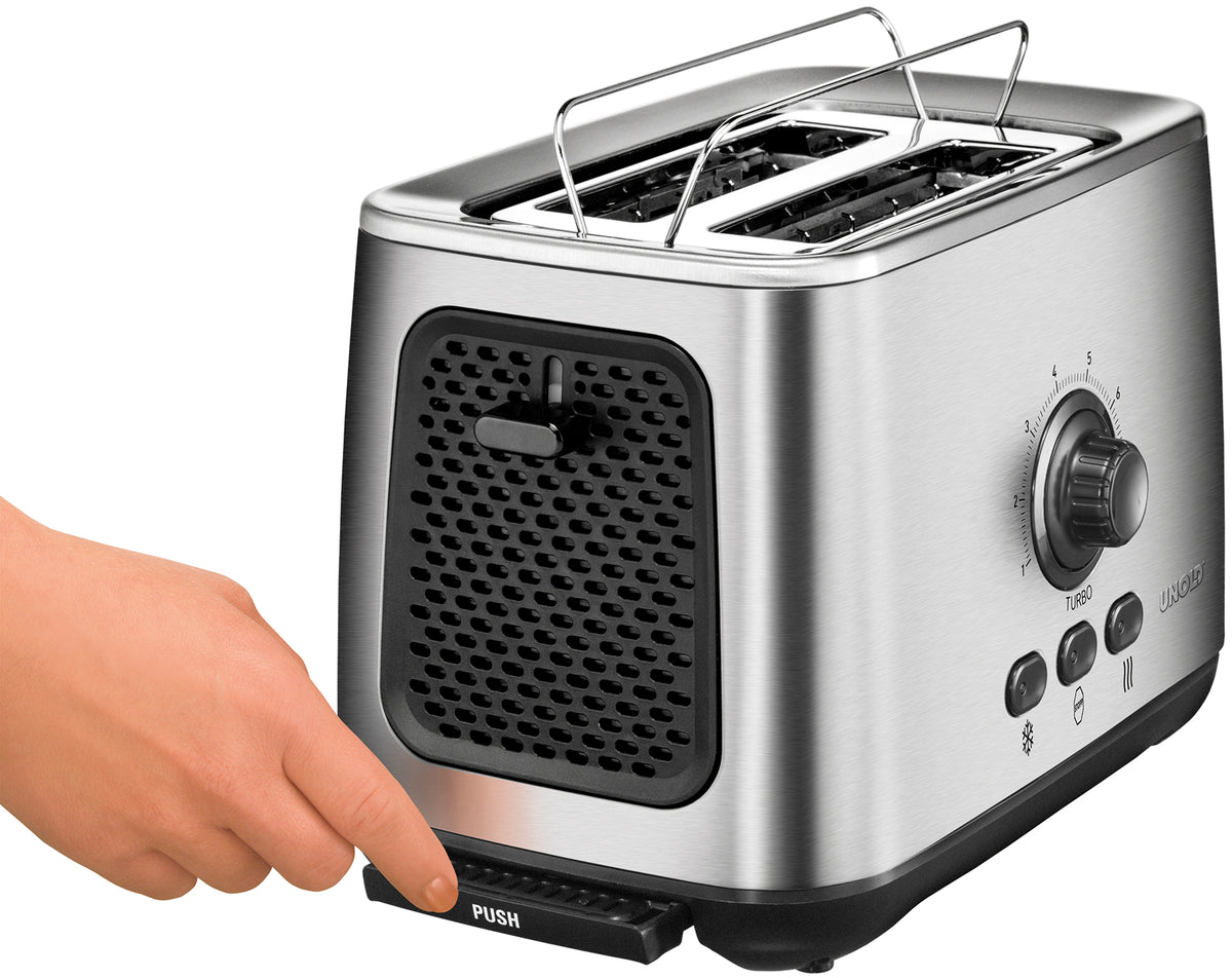 Eine Hand zieht die mit PUSH beschriftete Krümelschublade aus dem Unold Turbo Toaster B-Ware, einem Edelstahl-Zweischlitztoaster mit Bedientasten und Drehregler an der Seite.