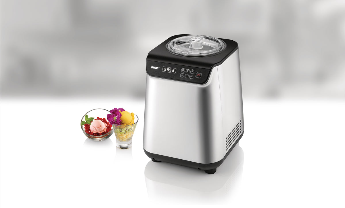 Die Unold Eismaschine Uno inklusive Eisbuch 1,2 L, eine elegante silberne Eismaschine mit Digitalanzeige und Tasten, steht neben zwei Glasschalen mit buntem Eis und Sorbet auf einer weißen Oberfläche.