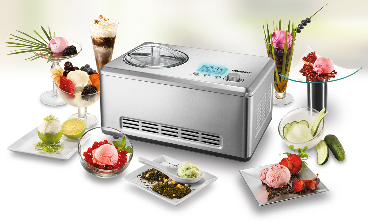 Die Unold Eismaschine Nobile inklusive Eisbuch 2,0 L steht auf einer weißen Fläche, umgeben von Schalen und Gläsern mit buntem Eis, Sorbet und Fruchtgarnituren. Das Display ist beleuchtet.