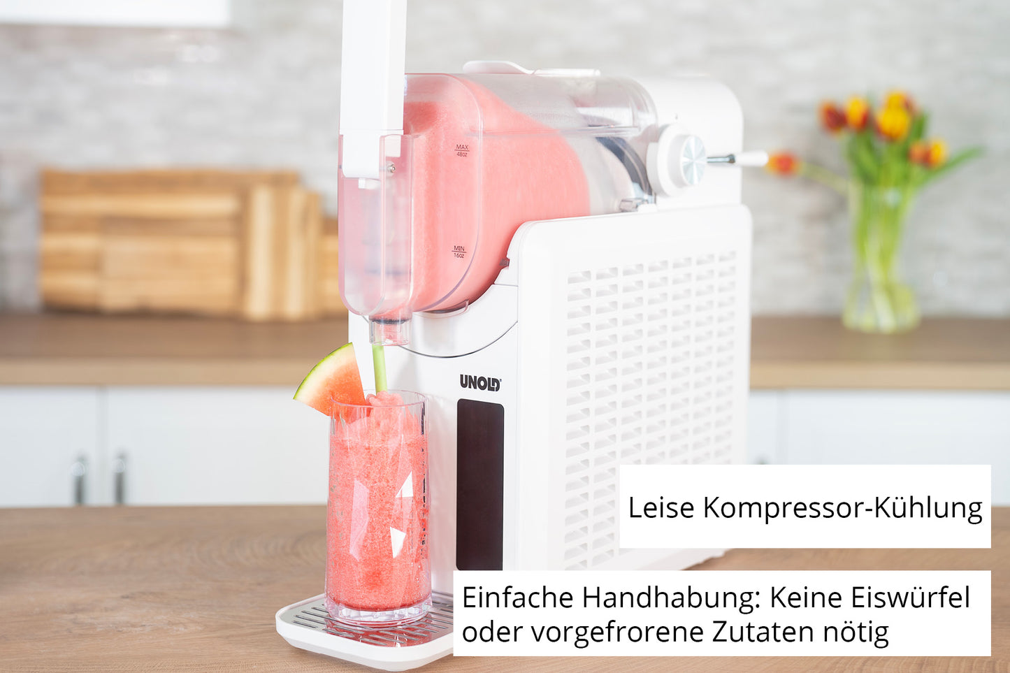 Die Unold Slush-Eismaschine Susi spendet rosa Wassermelonen-Slush in ein Glas mit einer Wassermelonenscheibe. Der Text lautet: Leise Kompressor-Kühlung und einfache Handhabung – keine Eiswürfel oder vorgefrorene Zutaten nötig.