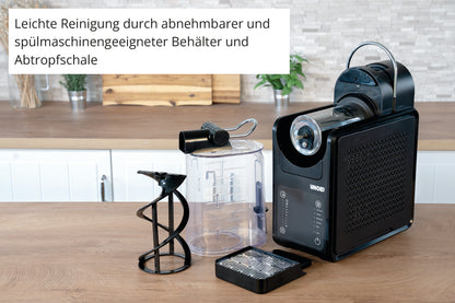 Die Slush-Eismaschine Stella von Unold steht auf der Küchenzeile, ihre herausnehmbaren Teile - Wassertank, Auffangschale und Rührwerk - sind ausgestellt. Deutsche Hinweise betonen die einfache Reinigung dank spülmaschinenfester Teile.