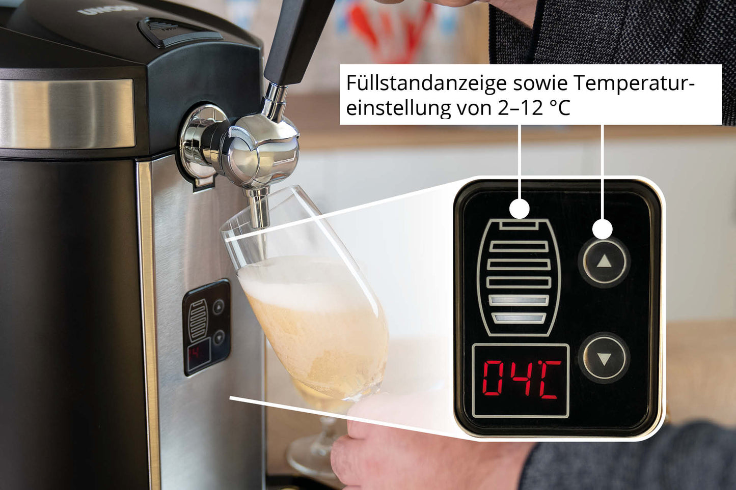 Eine Hand schenkt Bier aus der Zapfanlage „Unold Bierzapfanlage Franzl“ in ein Glas ein. Ein Einschub zeigt eine Digitalanzeige bei 04 °C mit deutsch beschrifteten Tasten: Füllstandanzeige und Temperatureinstellung von 2–12 °C.
