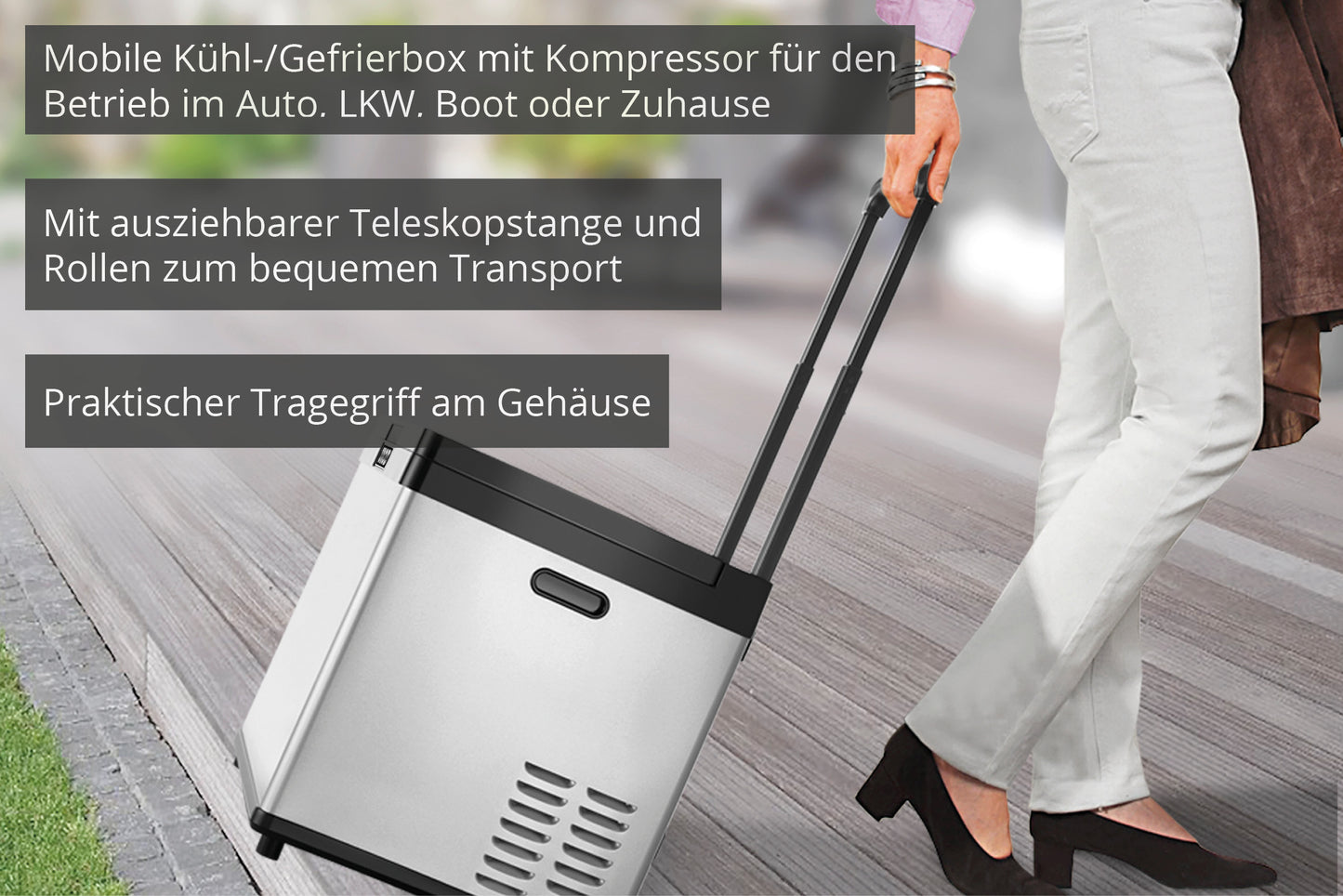 Eine Person zieht die Unold Kühl-/Gefrierbox Mobil mit Teleskopgriff und Rädern über einen Holzweg. Ein eingeblendeter Text hebt die Funktionen hervor: Kompressorbetrieb, Teleskopgriff, einfacher Transport und praktischer Tragegriff.