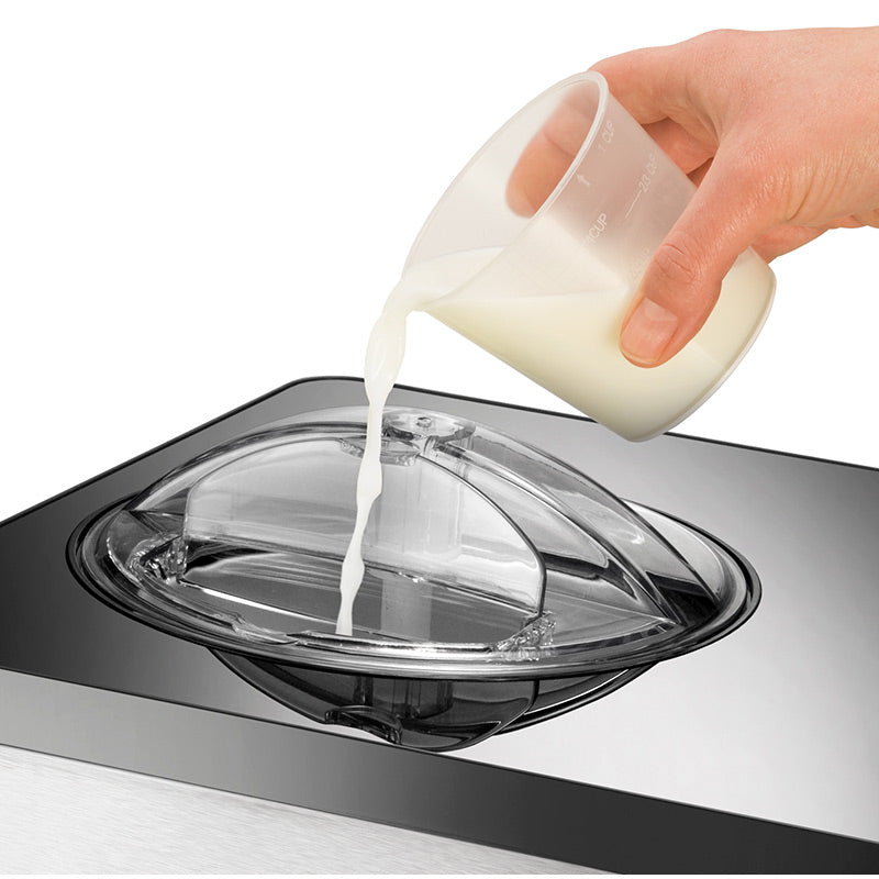 Eine Hand gießt Milch aus einem Messbecher in den transparenten Deckel der Unold Eismaschine Gusto inklusive Eisbuch 2 L, einer Eismaschine aus Edelstahl.