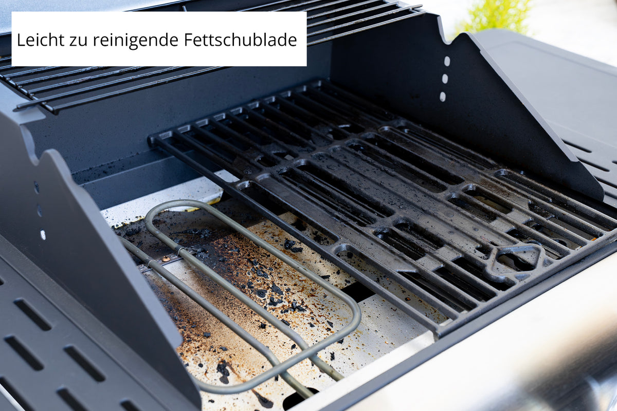 Nahaufnahme des Unold Barbecue Grill-Wagen Buddy zeigt fettige Roste, Rückstände, sichtbares Heizelement und Grillteile. Auf einem deutschen Schild steht "Leicht zu reinigende Fettschublade".