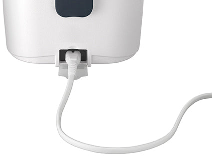 Nahaufnahme eines weißen Netzkabels, das an der Rückseite der Unold Lunchbox eingesteckt ist, einem weißen elektronischen Gerät, das auf einem schlichten Hintergrund dargestellt ist.