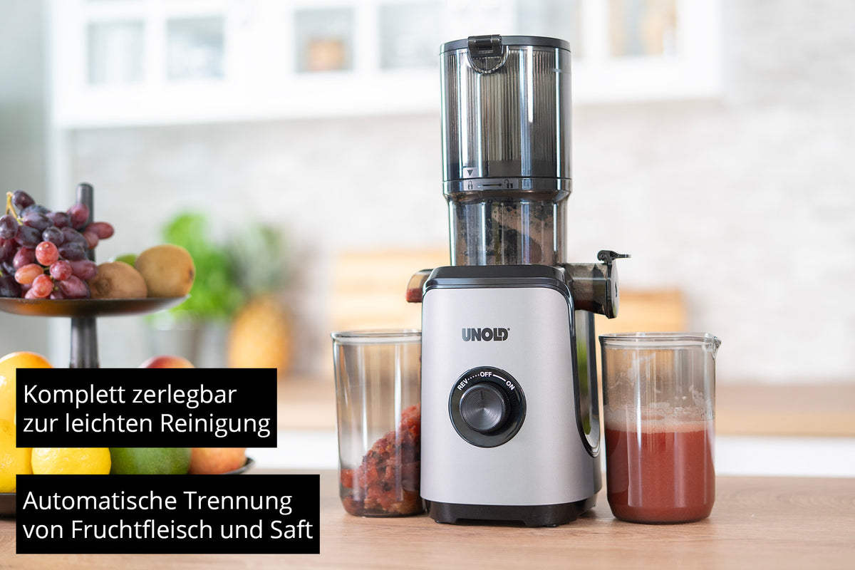 Der Unold Slow Juicer Sam steht auf einer Küchentheke mit Behältern für getrenntes Fruchtfleisch und Saft. Der deutsche Text hebt die einfache Reinigung und die automatische Trennung hervor. Im Hintergrund ist eine Obstschale zu sehen.