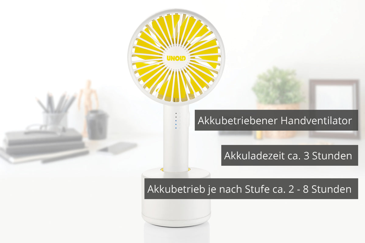 Auf einem Schreibtisch steht ein gelb-weißer Unold HANDVENTILATOR BREEZY SWING mit der Aufschrift: Akkubetriebener Handventilator, Akkuladezeit ca. 3 Stunden, Akkubetrieb je nach Stufe ca. 2-8 Stunden.