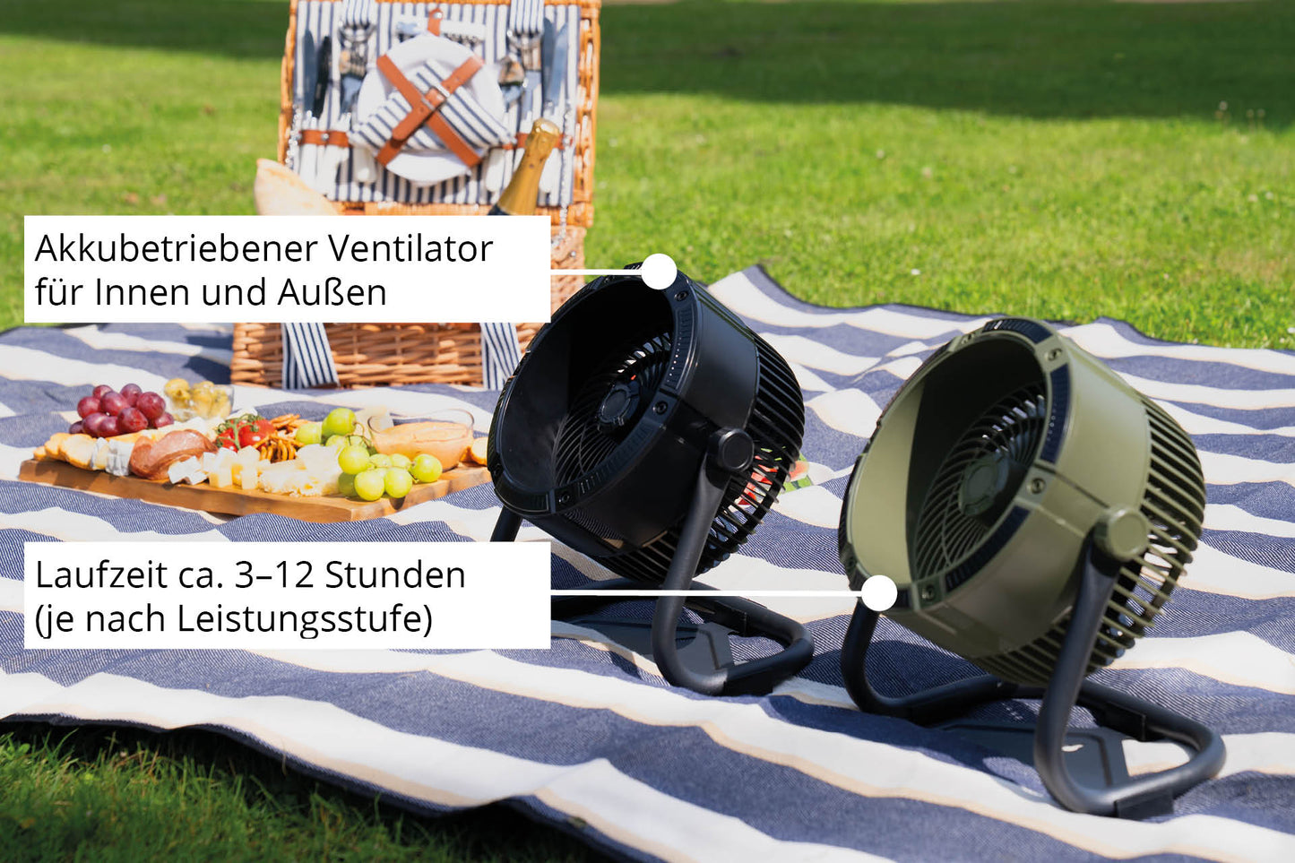 Zwei Unold Akkuventilatoren Outdoor, einer schwarz und einer grün, stehen auf einer gestreiften Decke neben einem Picknickkorb und Essen. Diese tragbaren Ventilatoren sind ideal für den Innen- und Außenbereich und bieten 3–12 Stunden kabellose Laufzeit.