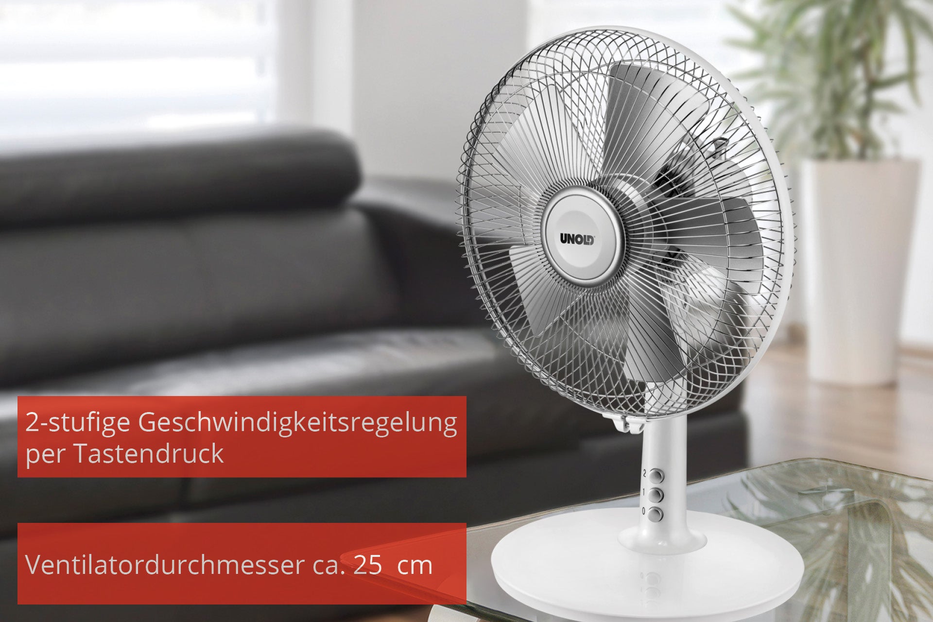 Der Unold TISCHVENTILATOR SILVERLINE, ein silberner Tischventilator mit rundem Metallgitter, steht auf einem Glastisch. Der deutsche Text hebt die 2-stufige Tastensteuerung und den ca. 25 cm großen Ventilatordurchmesser hervor. Der Hintergrund ist sanft verschwommen.