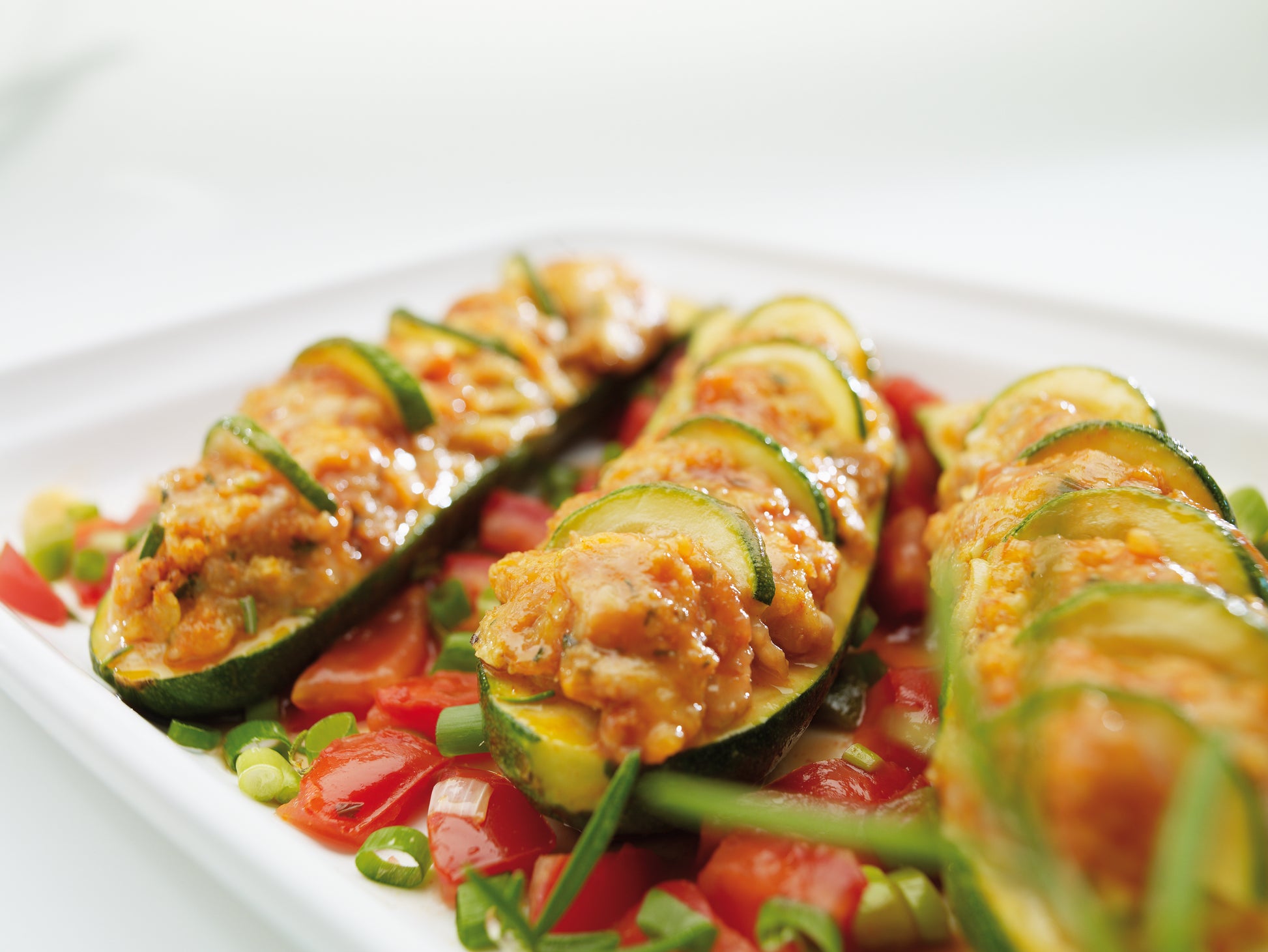 Im „Das große ESGE-Zauberstab® Koch- und Zauberbuch“ von ESGE Zauberstab finden Sie Rezepte wie Zucchinischiffchen mit Käse-Tomaten-Füllung, garniert und serviert auf gehackten Tomaten und Frühlingszwiebeln.