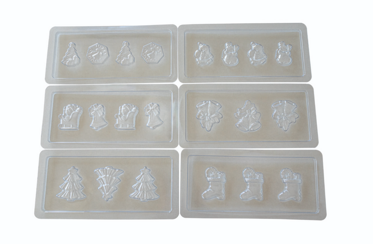 Das Unold Schokoladenform-Set Weihnachten umfasst sechs durchsichtige Kunststoffformen mit festlichen Formen – Weihnachtsbäume, Schneemänner, Glocken, Strümpfe und Ornamente –, die auf beigem Hintergrund in zwei Reihen mit jeweils drei Formen dargestellt sind.
