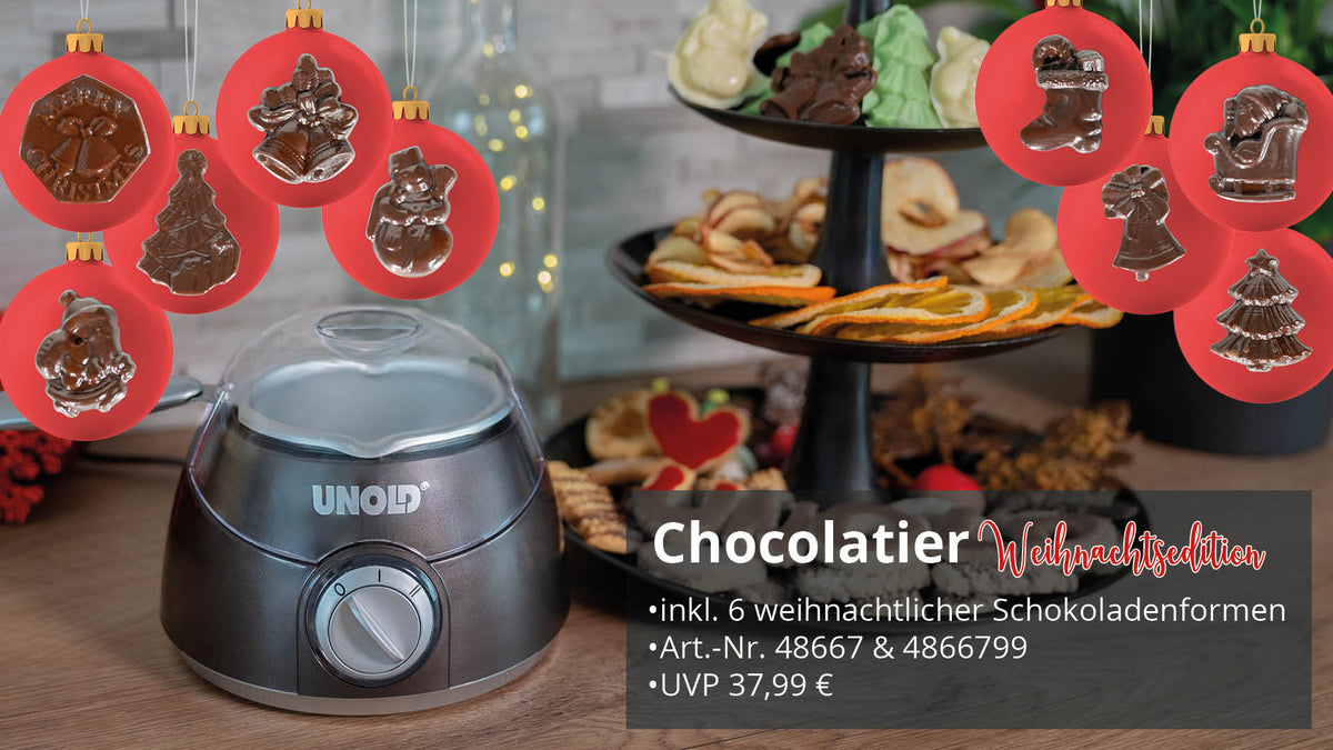 Die Weihnachtsedition von Unold Chocolatier steht auf einem Tresen neben einem mehrstöckigen Plätzchenteller. Darüber hängen sechs weihnachtliche Schokoladenformen, während ein festlicher deutscher Text das Produkt und seinen Preis hervorhebt.