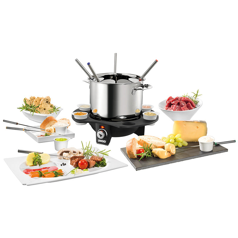 Das Unold Fondue Elégance, ein Edelstahltopf mit Spießen auf einem schwarzen elektrischen Sockel, ist umgeben von Fleisch, Käse, Brot, Gemüse, Trauben und Soßen – perfekt für ein elegantes Fondue-Essen.