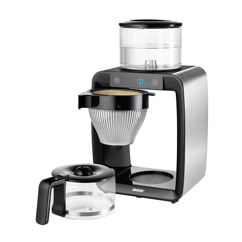 Der Unold Kaffeeautomat Aroma Star verfügt über eine digitale Anzeige, Edelstahlakzente, einen transparenten Wasserbehälter oben, einen zentralen konischen Filterkorb und eine Glaskaraffe mit schwarzem Griff.
