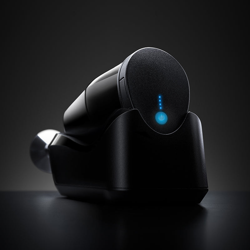 Der Unold ESGE-Zauberstab® cordless PLUS Schwarz, ein elegantes schwarzes Elektronikgerät mit leuchtend blauem Einschaltknopf und Kontrollleuchten, steht auf einer dunklen Oberfläche vor einem dunklen Hintergrund.