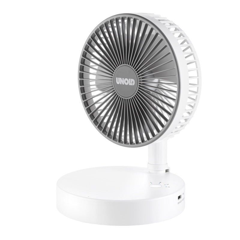 Der kompakte, moderne, weiß-graue TELESKOP-VENTI CORDLESS Tischventilator von Unold verfügt über einen runden Sockel, einen USB-Anschluss und das Unold-Logo auf dem Frontgitter. Der Ventilator ist leicht nach oben geneigt.