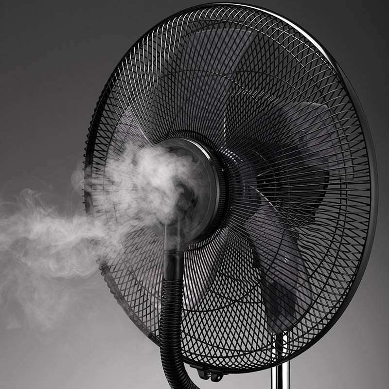 Eine Nahaufnahme des Unold STANDVENTILATOR NEBULA TOUCH DIGITAL, eines schwarzen elektrischen Ventilators, der Nebel durch seine Düse ausstößt, vor einem dunklen Hintergrund.